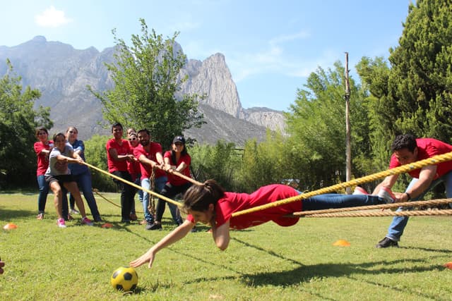 Participante cruzando un obstáculo al aire libre, mostrando cómo las actividades de ALYAX fortalecen la cohesión del equipo