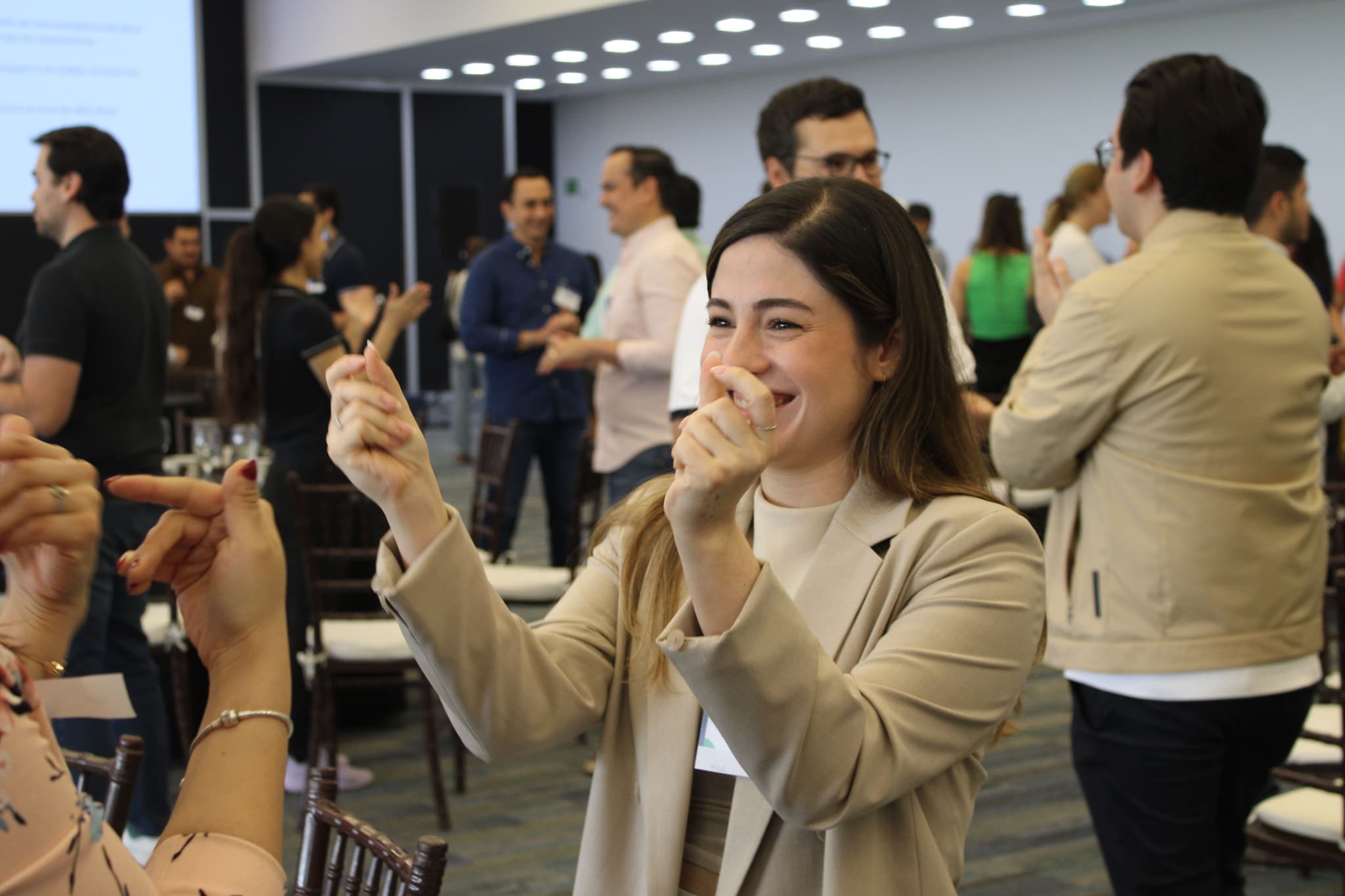 Participante sonriendo mientras reflexiona durante una actividad de Team Building, mostrando entusiasmo por el aprendizaje